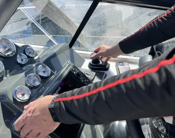 skipper driving motor yachtin marina